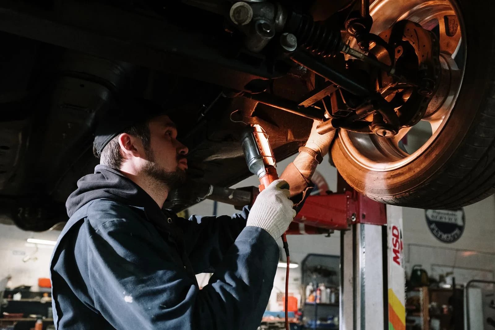 Mechanic under raised car — Auto Repair Shops & Mechanics marketing by TML Agency